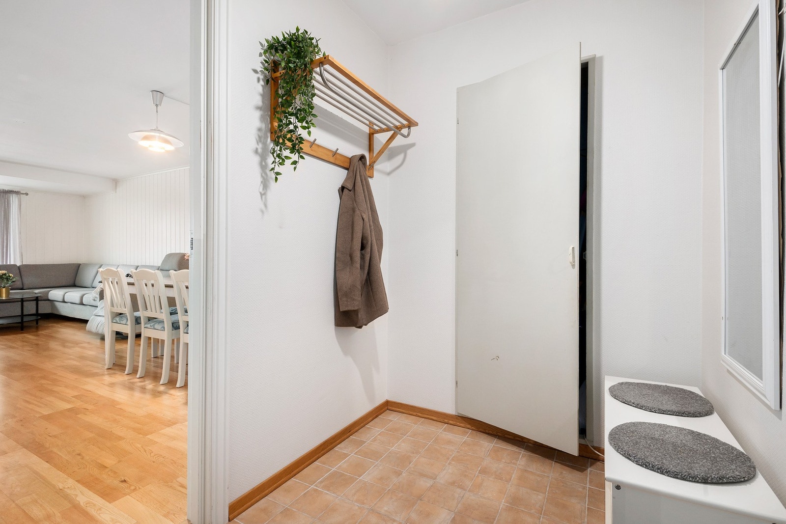 Praktisk entré med flislagt gulv og plass til sko og yttertøy. Galleribilde