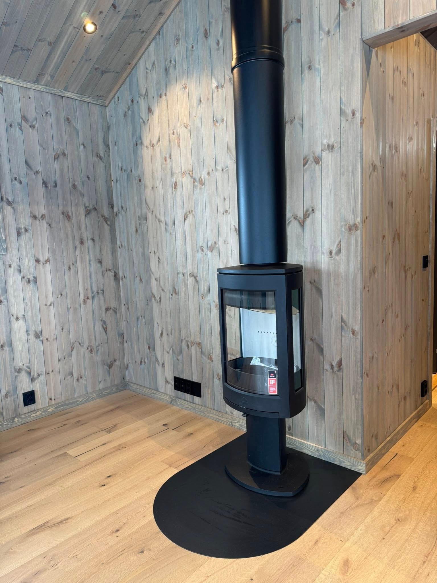 Jøtul ovn med stålpipe -foto fra den aktuelle hyttemodellen. Galleribilde