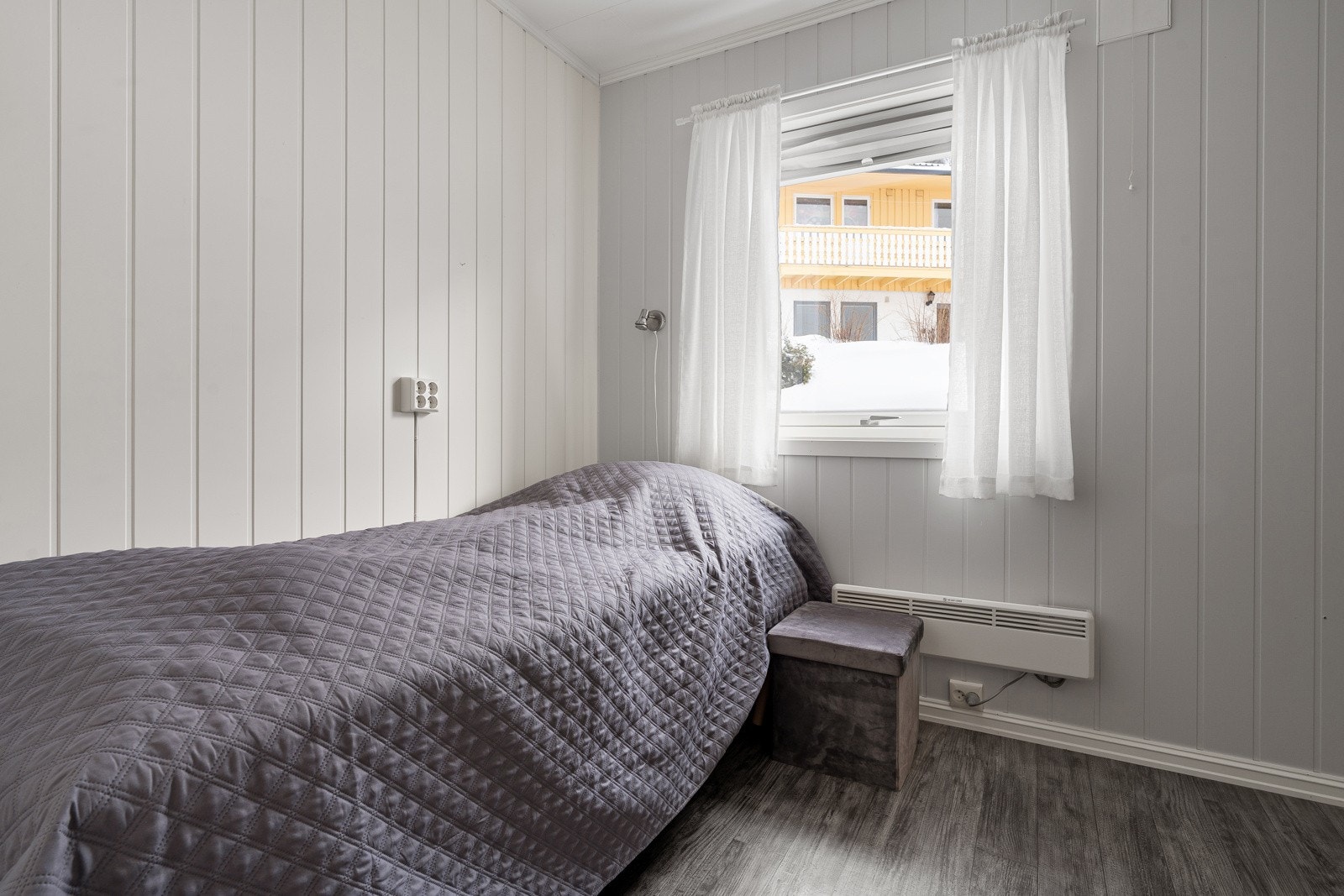 Soverom 2 med laminatgulv og malte plater på veggene