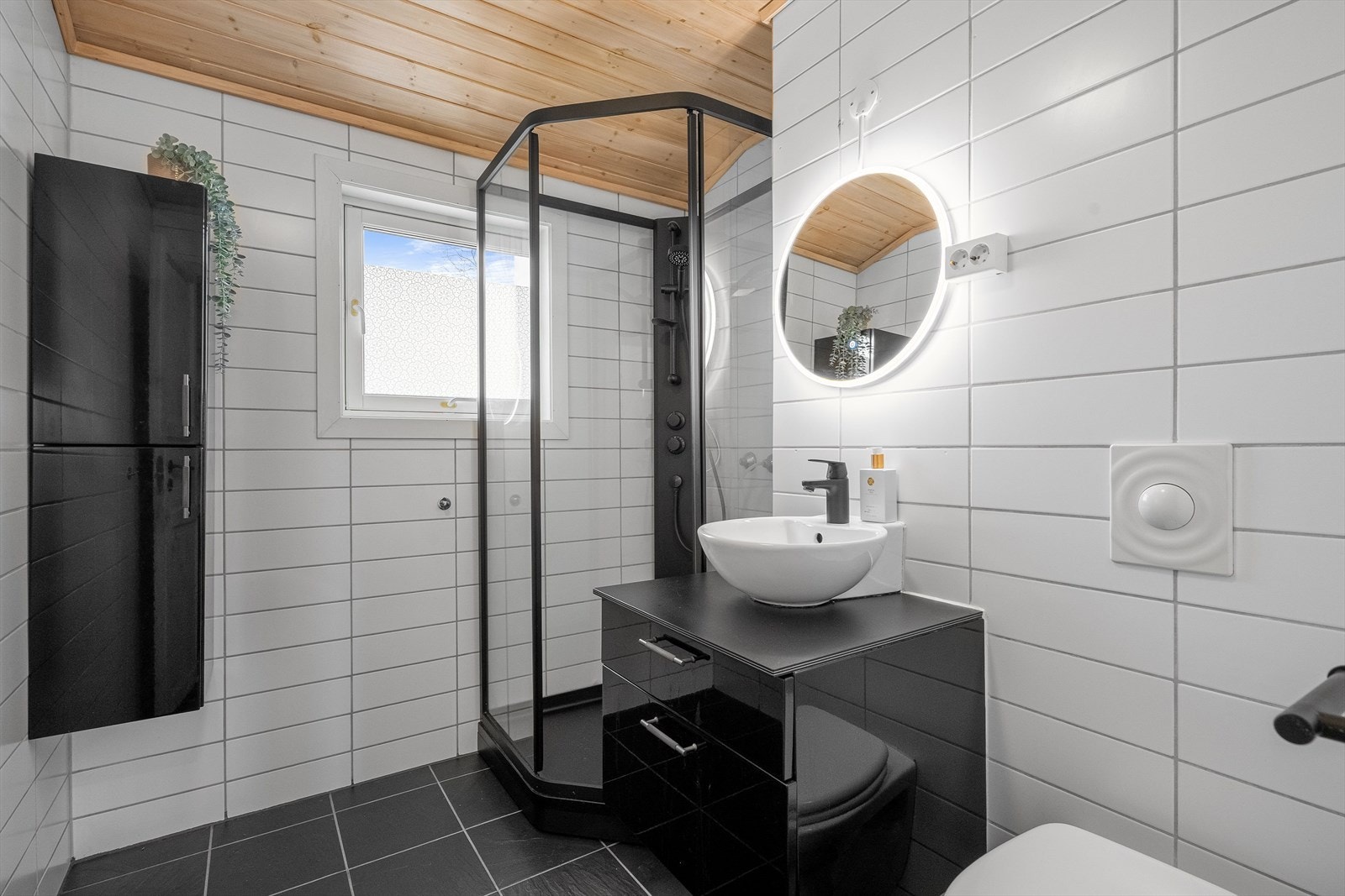 Badet ligger praktisk plassert ved entréen og har flislagte vegger og gulv, samt trepanel i himling. Galleribilde