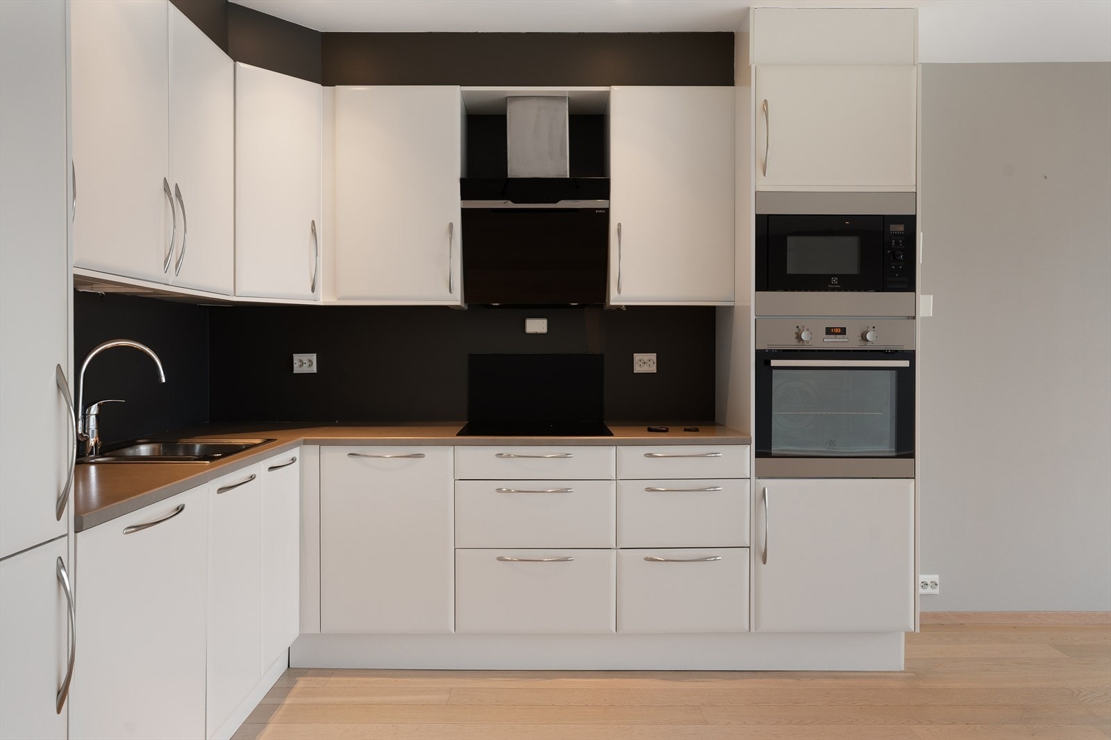 Kjøkkenet har innredning med slette fronter og laminat benkeplate - det er integrert kjøleskap, oppvaskmaskin, platetopp, stekeovn og mikrobølgeovn Galleribilde