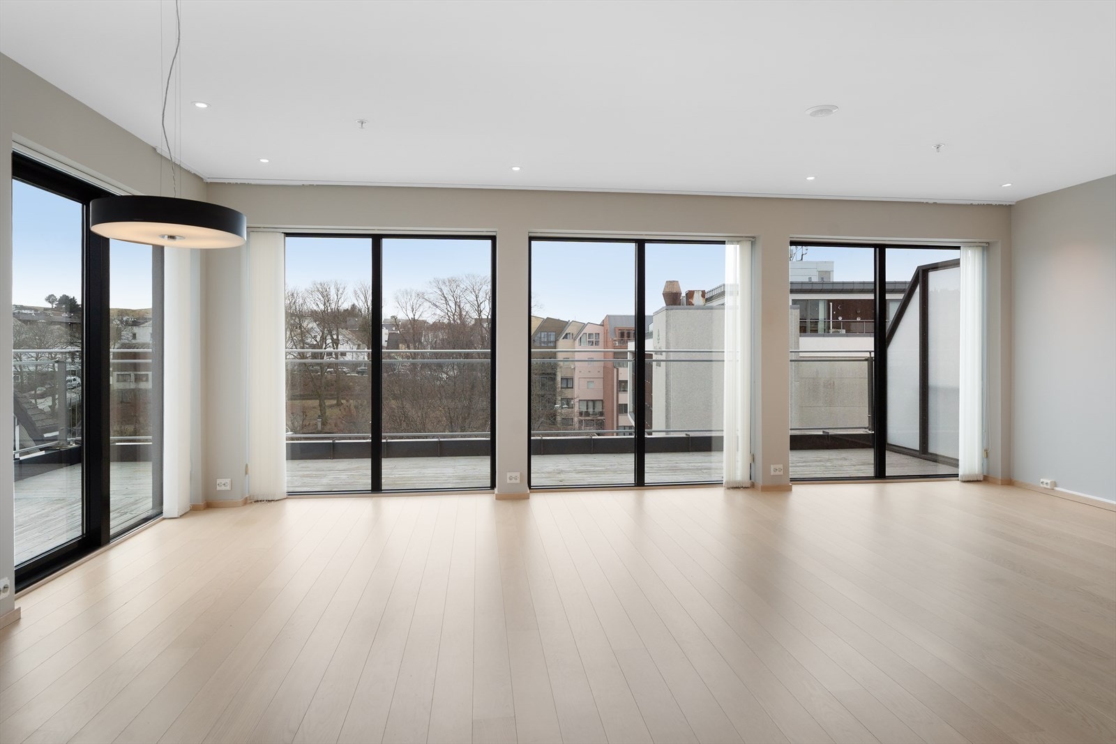 De store vinduene som strekker seg ned til gulvet slipper inn rikelig med naturlig lys - det er også montert lamellgardiner i vinduene Galleribilde