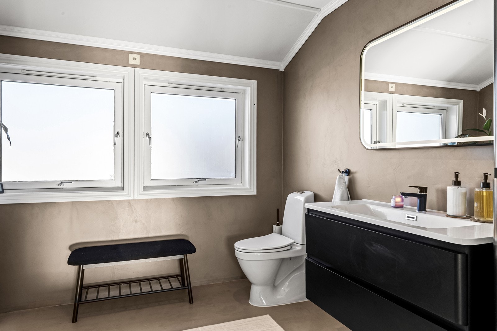 Romslig bad i 2. etasje med dusjkabinett i nisje, toalett, servant i skapinnredning, sideskap og speil. Galleribilde