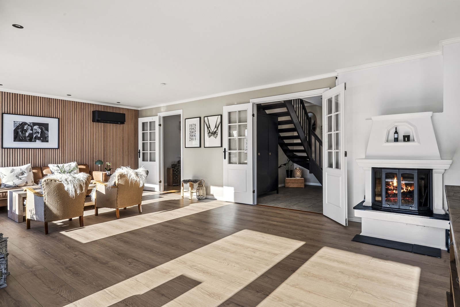 Fra hallen går man gjennom doble glassdører og inn i storstua. Her finnes en peisovn for oppvarming Galleribilde