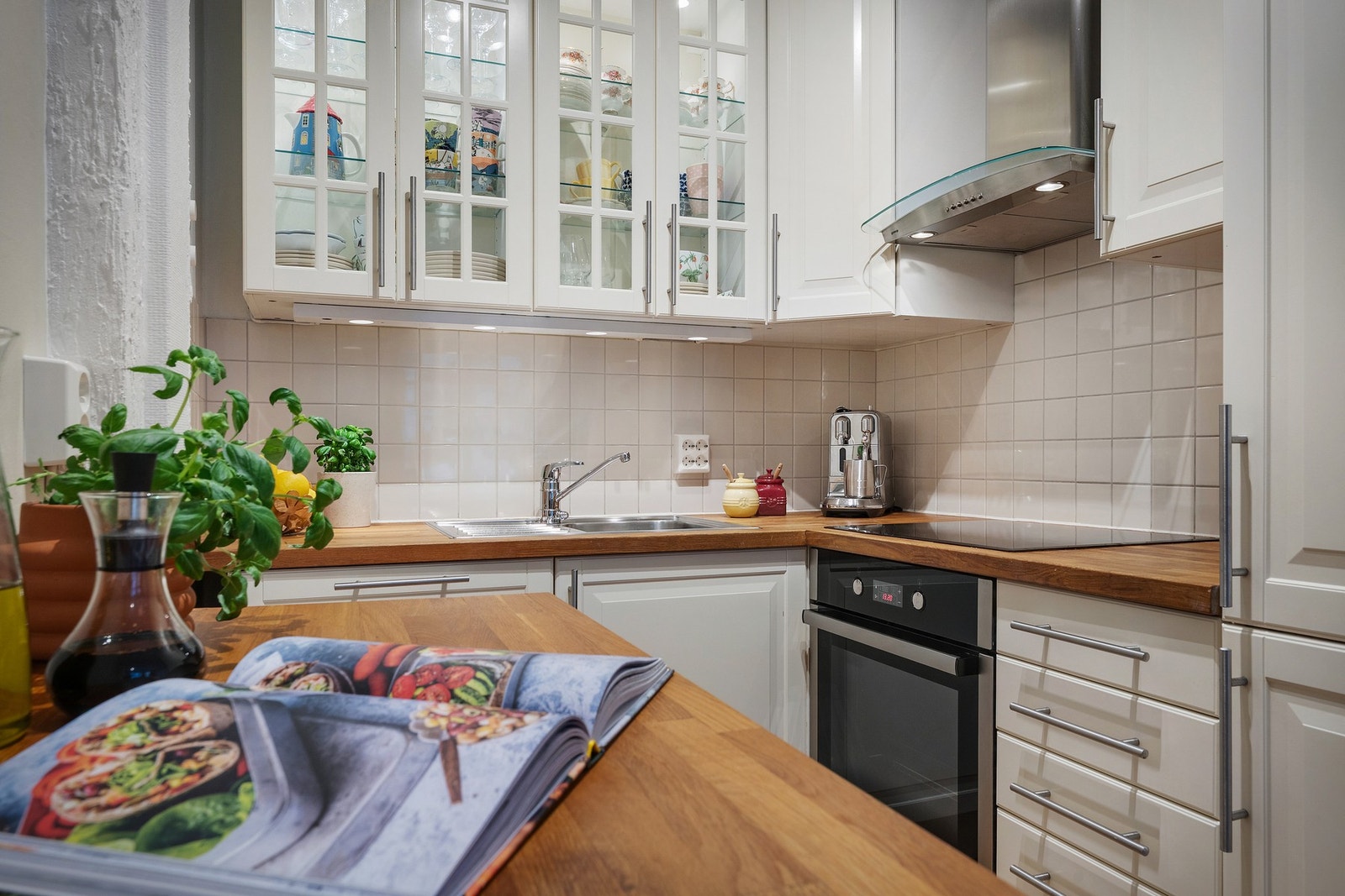 Kjøkkenet har kjøkkenskap med lys og glassfronter. Galleribilde