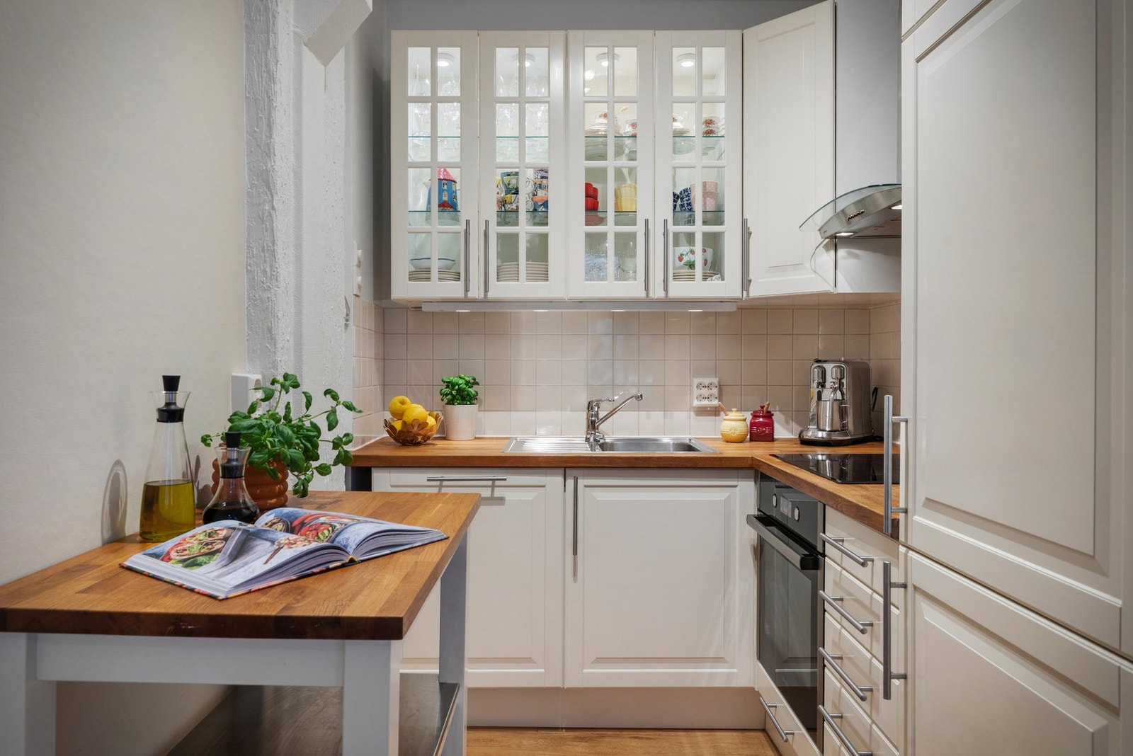 Et nydelig og lyst kjøkken med lyse fronter og heltre benkeplate med kjøkkenbeslag. Galleribilde