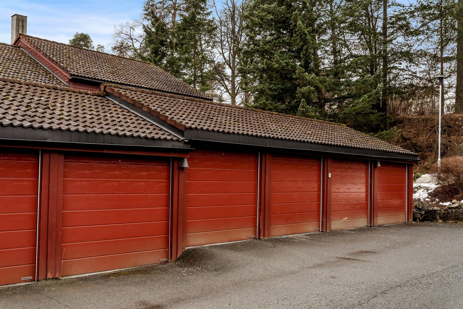 Det følger med en garasje i rekke, med egen elektrisk, låsbar port og indre skillevegger av nettinggjerde. Det er montert el-bil lader i garasjen. Galleribilde