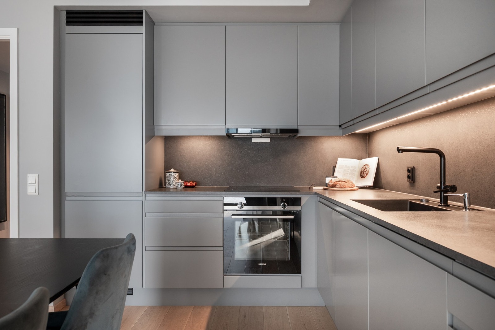 Kjøkkenet er utstyrt med integrerte hvitevarer som induksjonstopp, stekeovn, kjøl- og fryseskap, mikrobølgeovn og oppvaskmaskin. Galleribilde