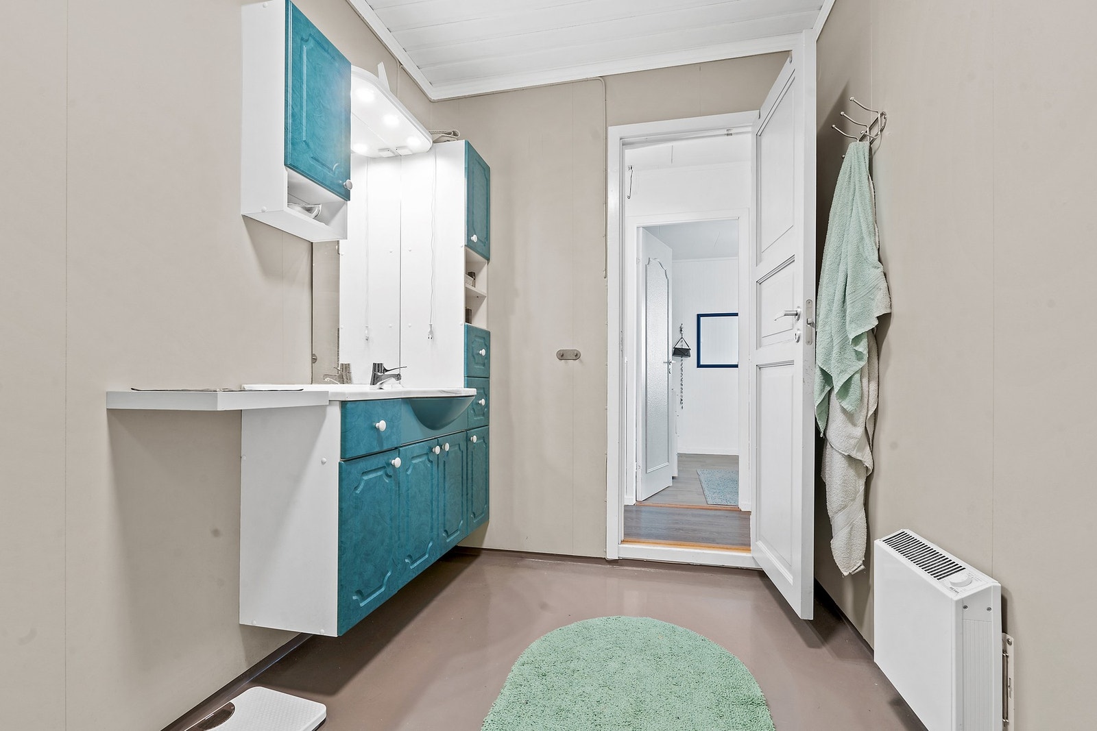 Rommet har malte plater på veggene og varmes opp av en panelovn. Overflatene ble behandlet i 2021. Galleribilde