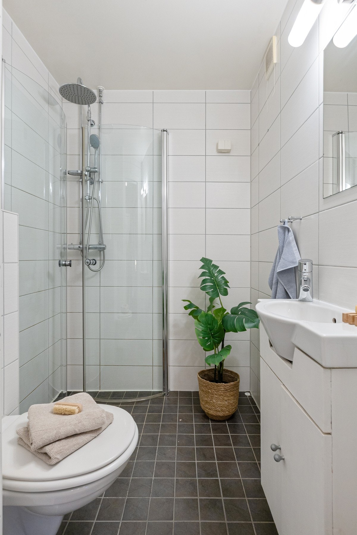 Badet er flislagt og fremstår funksjonelt med støpt betonggulv med varmekabler og fliser. Galleribilde