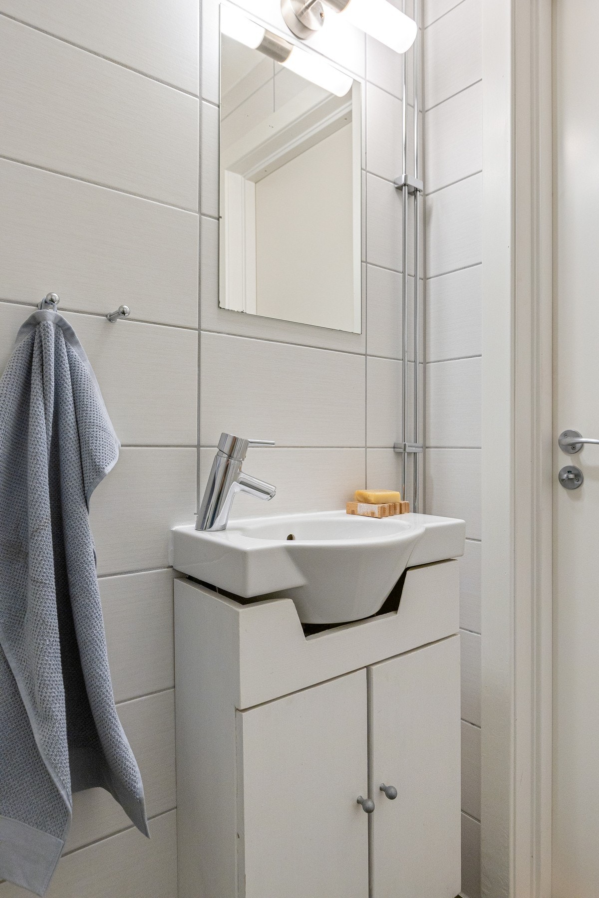 Rommet er innredet med vegghengt wc, servant med underskap, speil med overlys samt dusjhjørne med inn-/utadslående dusjdører i glass. Galleribilde