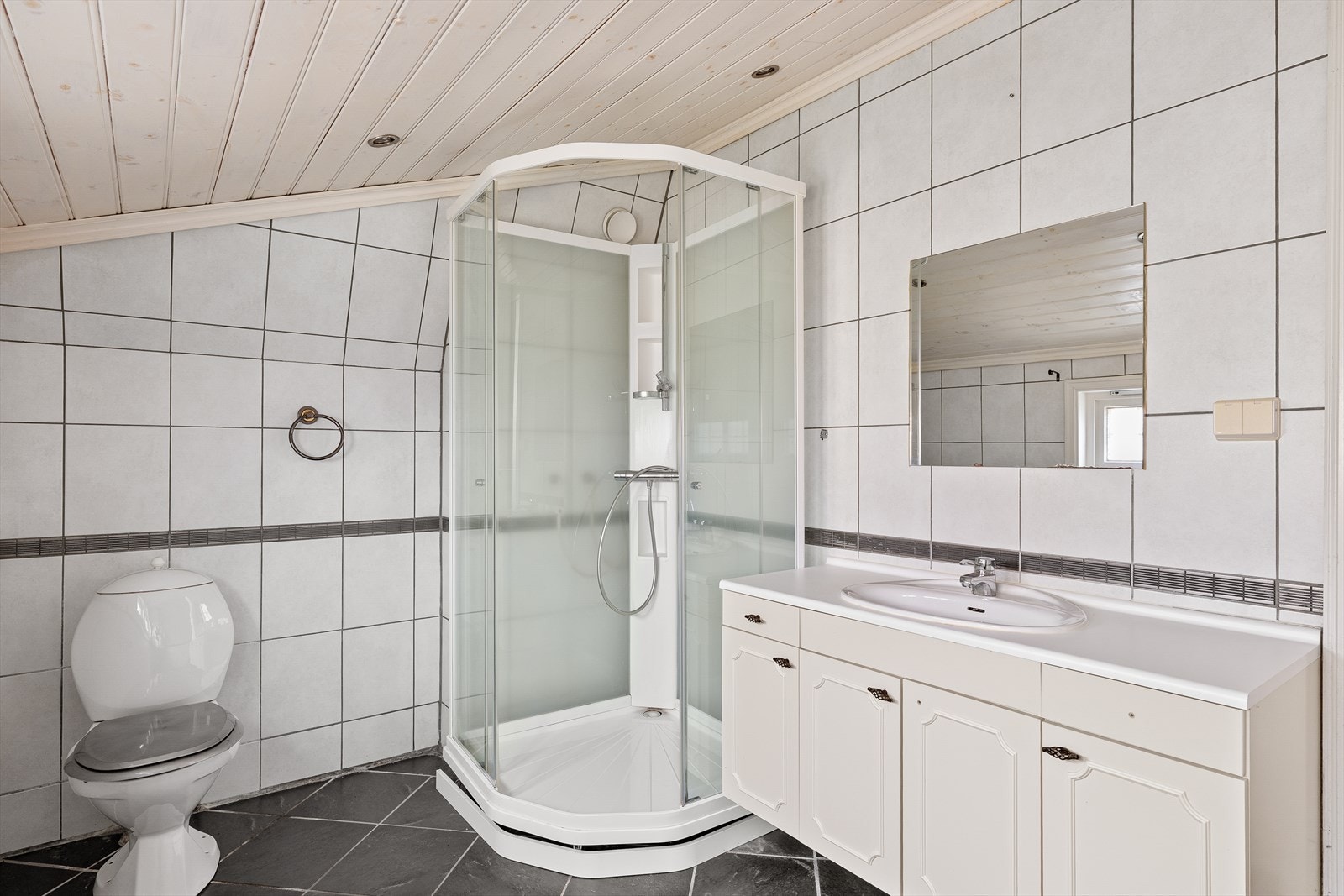 Badet har spotter i taket, dusjkabinett og vegghengt servant med god plass til oppbevaring. Galleribilde