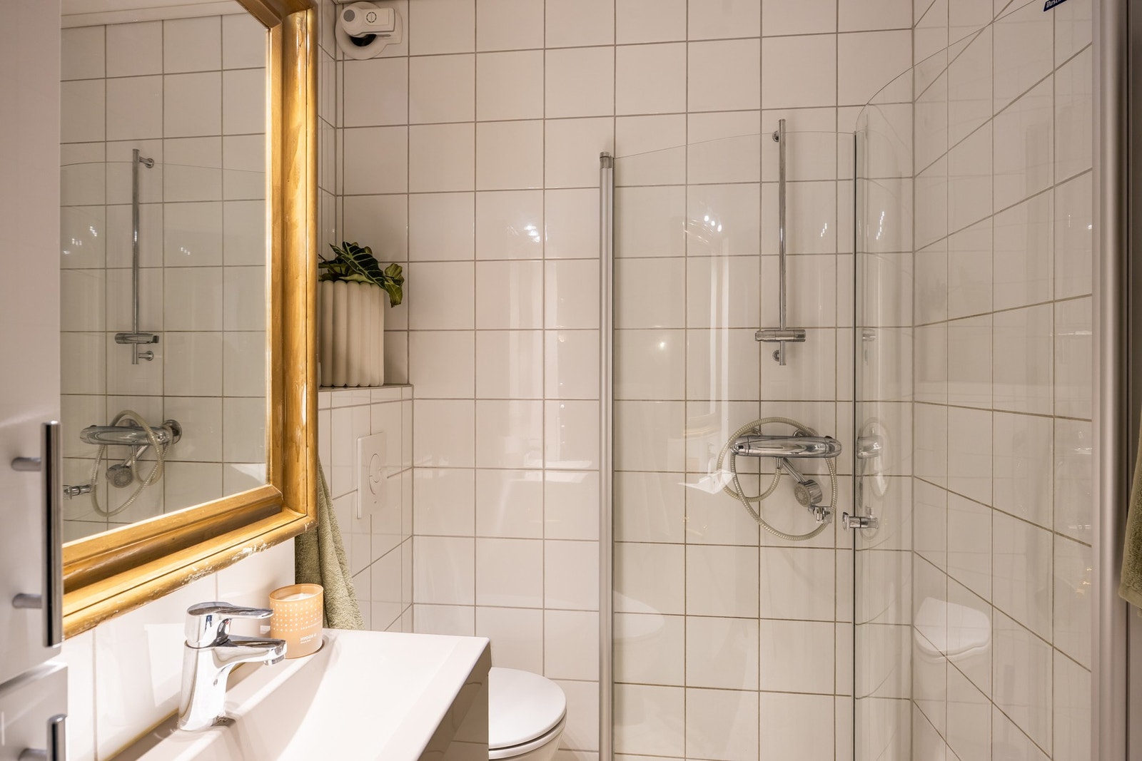Praktisk utnyttelse av oppbevaring og areal, innflettbare dusjdører, lagrinsskap, vegghengt toalett og servant. Galleribilde