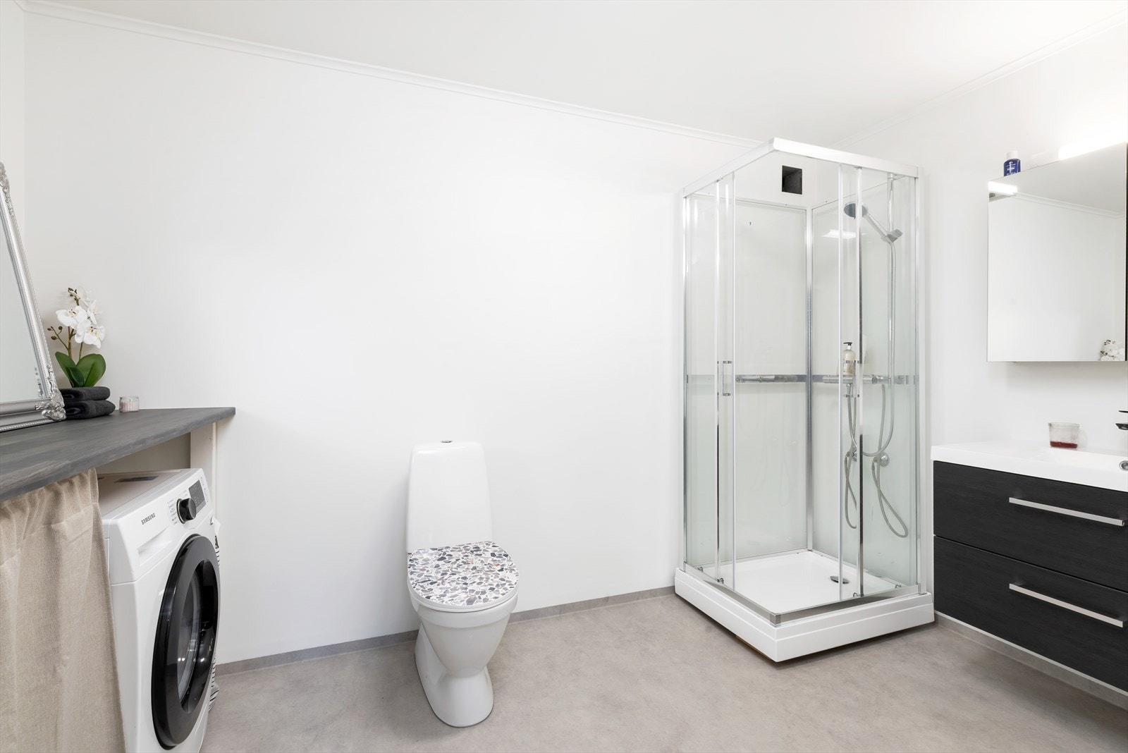 Stort bad innredet med dusjkabinett, wc og servant med skap. Galleribilde