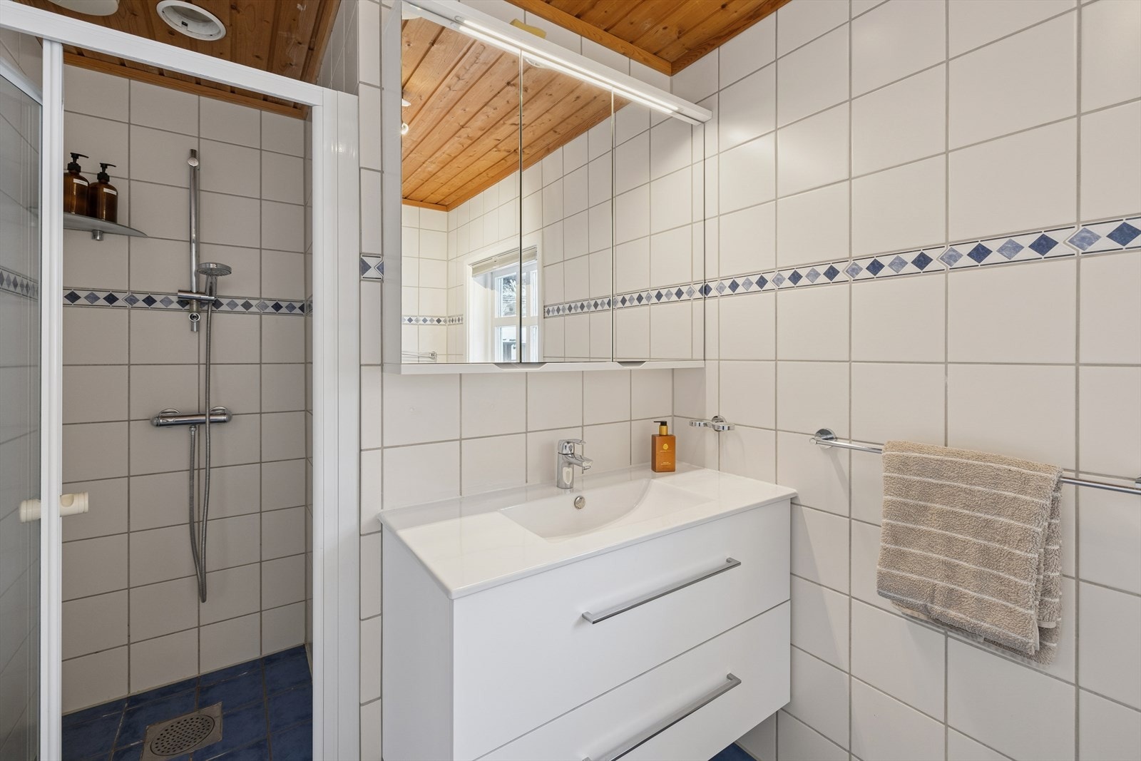 Rommet er innredet med servant med underskap og speil med tilhørende belysning, dusjvegger og badekar. Ventilasjonen er naturlig, med tilluft via vindu. Galleribilde