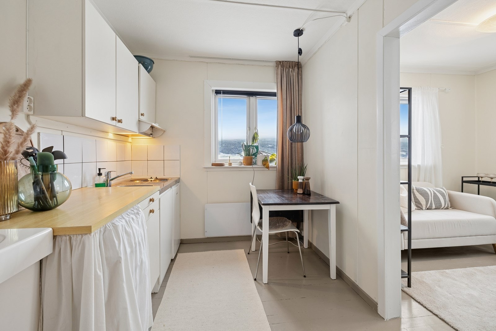 Kjøkkenet har laminerte skrog, glatte fronter og laminert benkeplate med kjøkkenkum. Plass til frittstående komfyr, kjøleskap. Her er det også egen inngang. Galleribilde