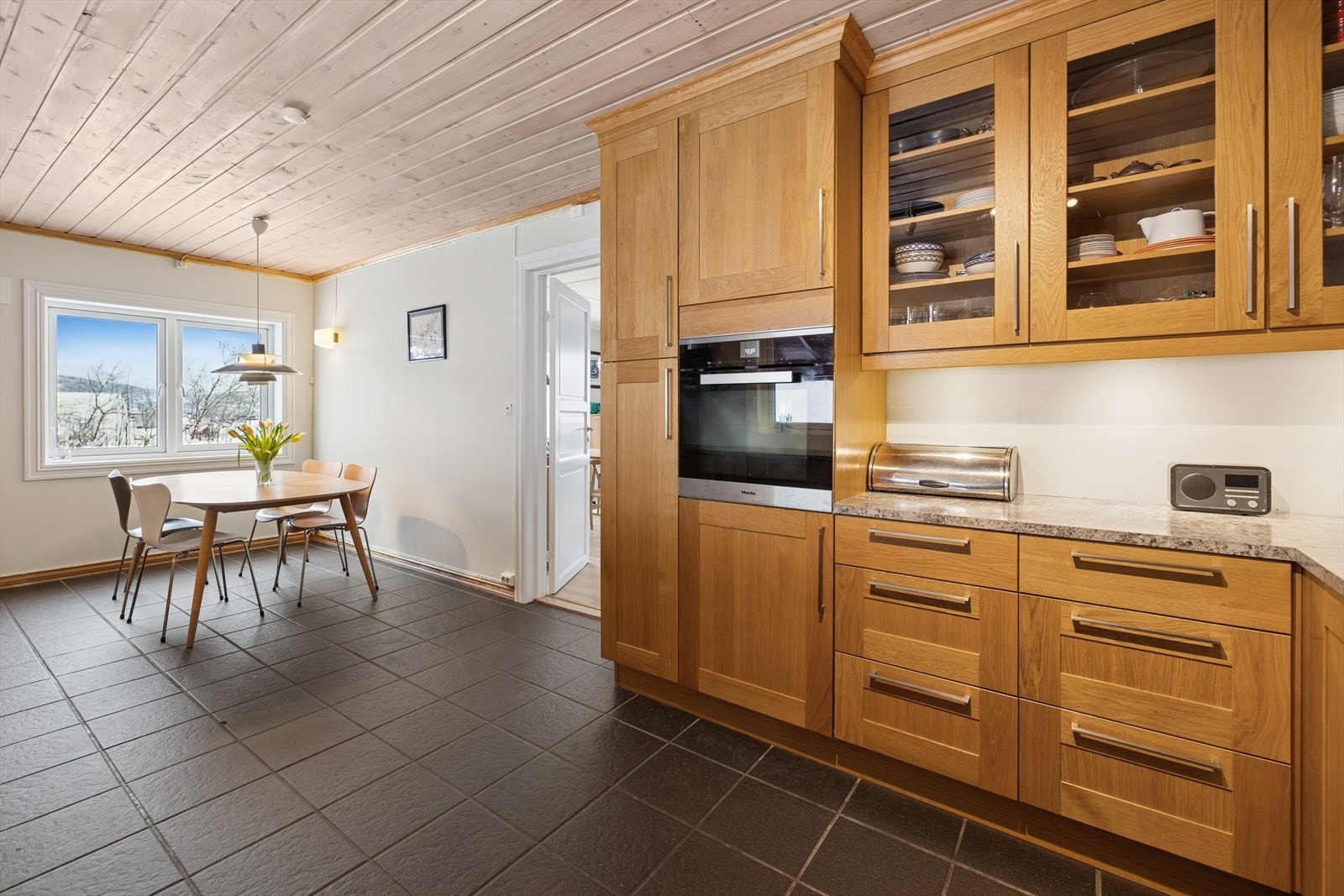 Delikat kjøkken fra 2015 med profilerte fronter, stedvis med glass og laminert benkeplate med kjøkkenkum. Galleribilde