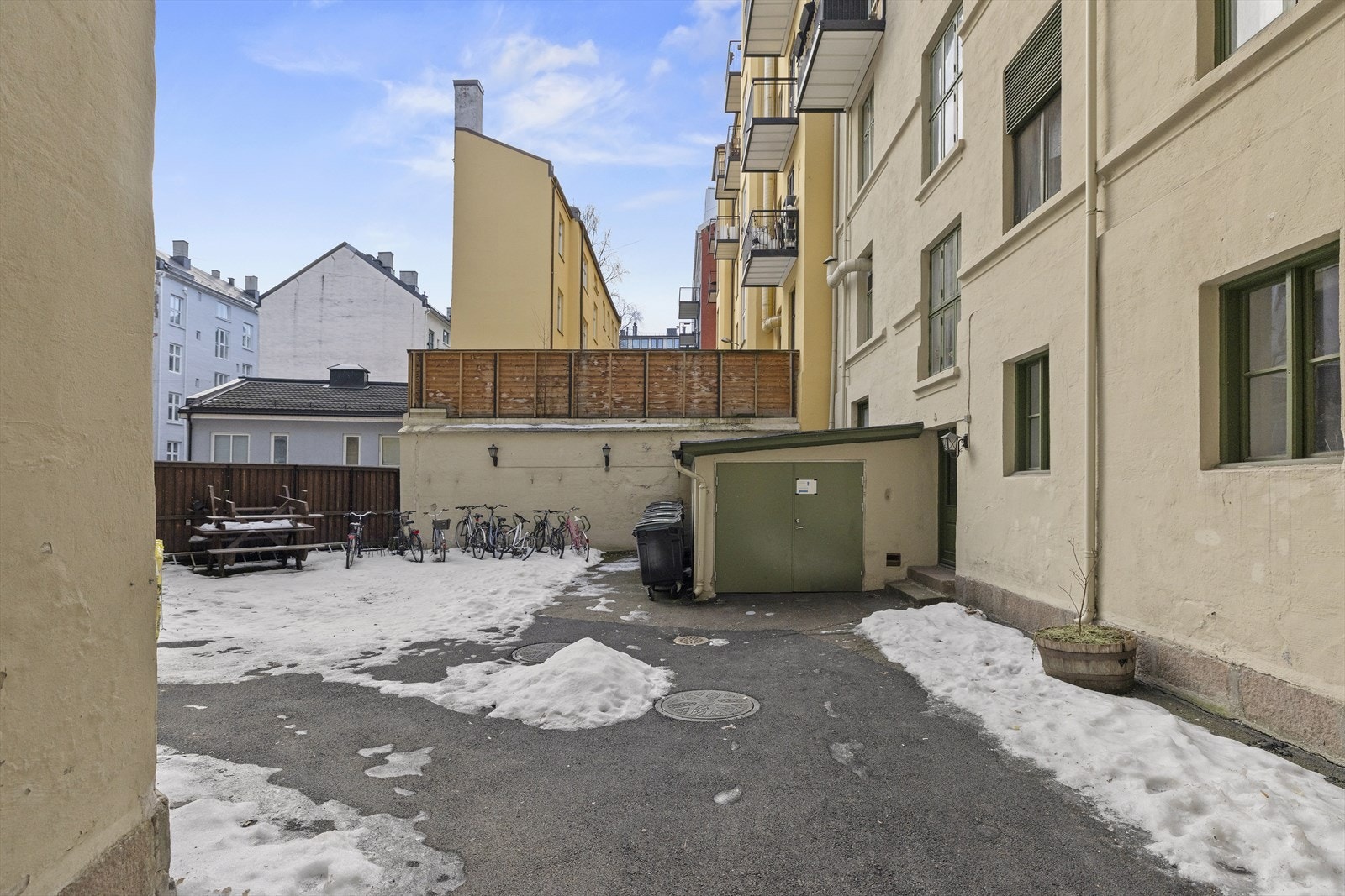 Indre gårdsrom med asfalterte flater, sittegruppe og sykkelparkering Galleribilde