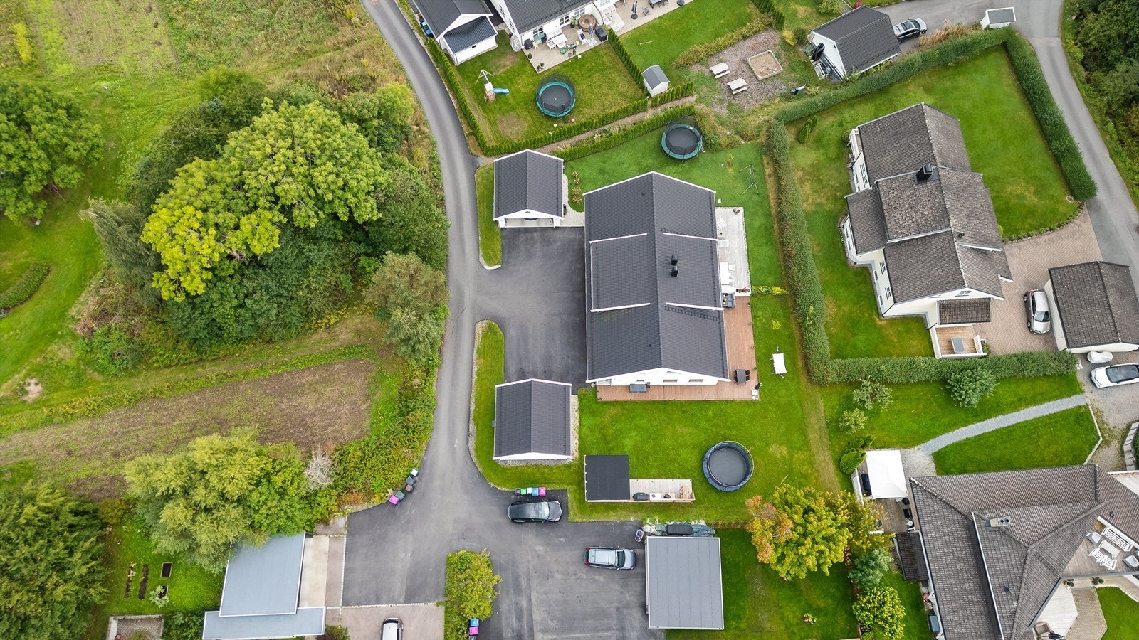 Tomt er opparbeidet med blant annet asfaltert gårdsplass, plenarealer og andre forskjellige beplantninger. Adkomst til boligen skjer via eget inngangsparti fra bakkeplan. Galleribilde