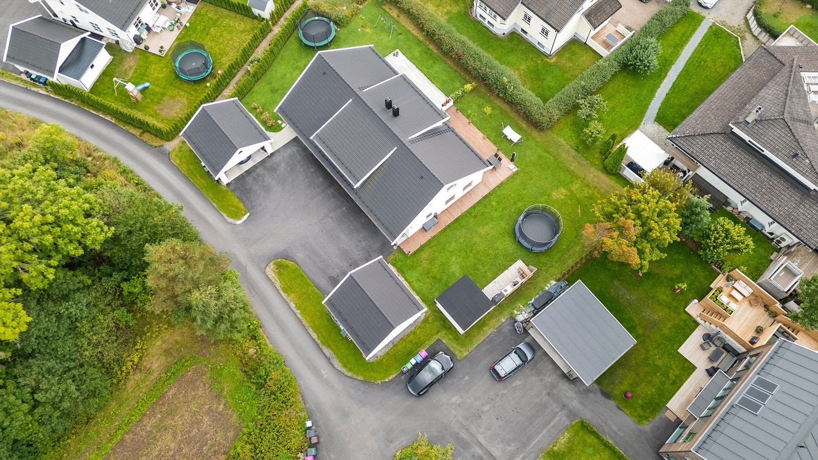 Tomt er opparbeidet med blant annet asfaltert gårdsplass, plenarealer og andre forskjellige beplantninger. Adkomst til boligen skjer via eget inngangsparti fra bakkeplan. Galleribilde