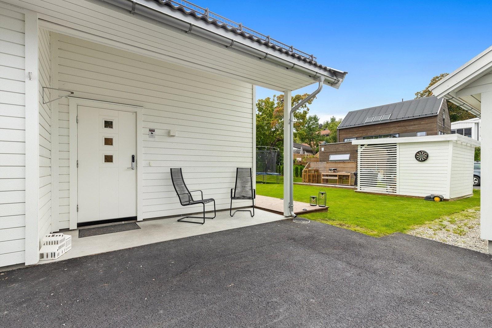 Overbygd inngangsparti og asfaltert gårdsplass. Galleribilde