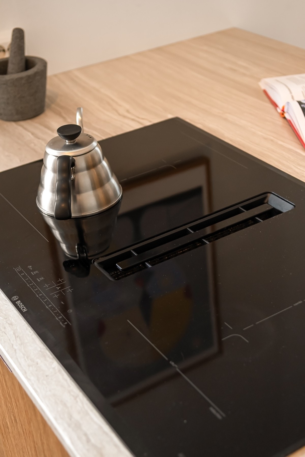 Integrerte hvitevarer som induksjonsplatetopp med ventilator, stekeovn, vinskap, oppvaskmaskin og kjøle/fryseskap Galleribilde