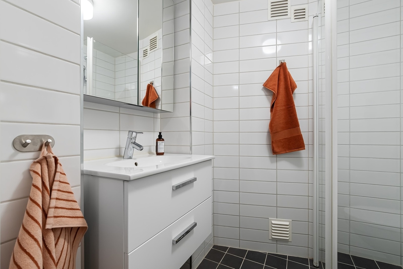 Her finner du dusjhjørne med glass innfallsdører, wc, servant med underskap og speilskap Galleribilde