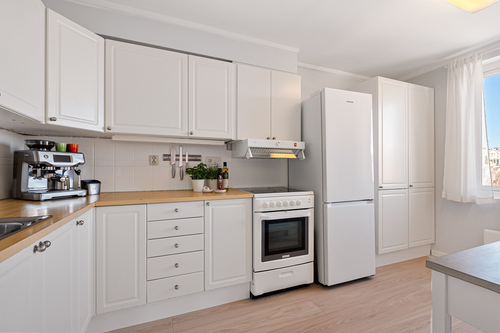 Lyst kjøkken med rikelig skap- og benkeplass. Galleribilde