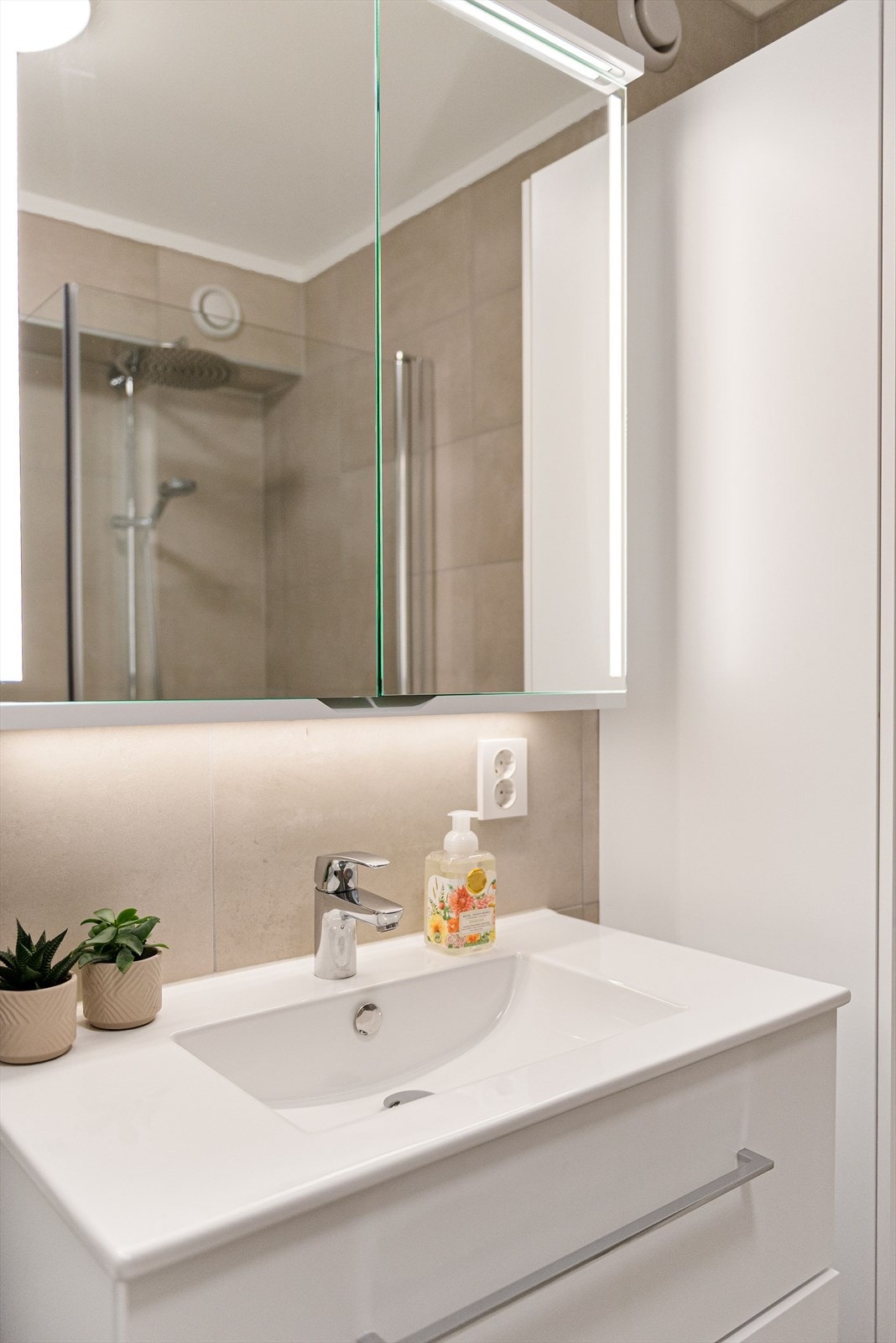 Lys innredning med tilhørende speilskap med belysning. Galleribilde