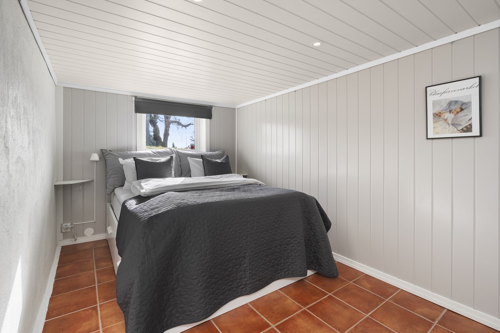 Lyst soverom med god plass til dobbeltseng, nattbord og garderobeskap Galleribilde