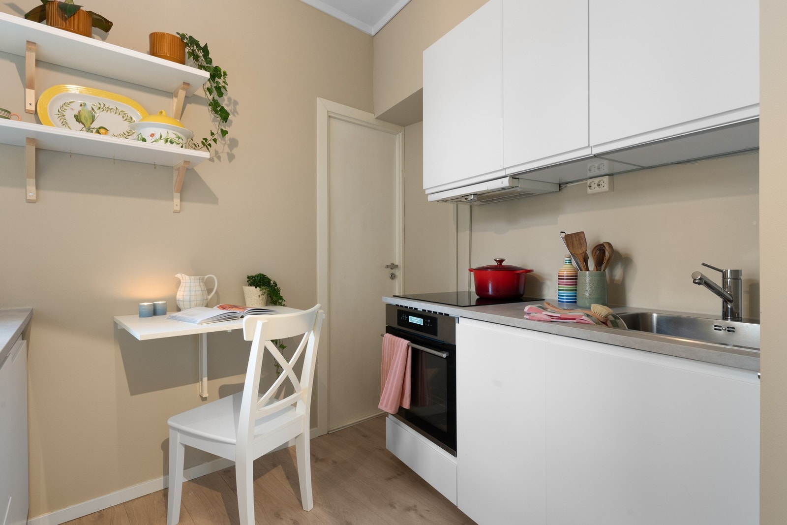 Kjøkkenet har innredning fra IKEA med hvite glatte fronter og benkeplate av laminat. Galleribilde