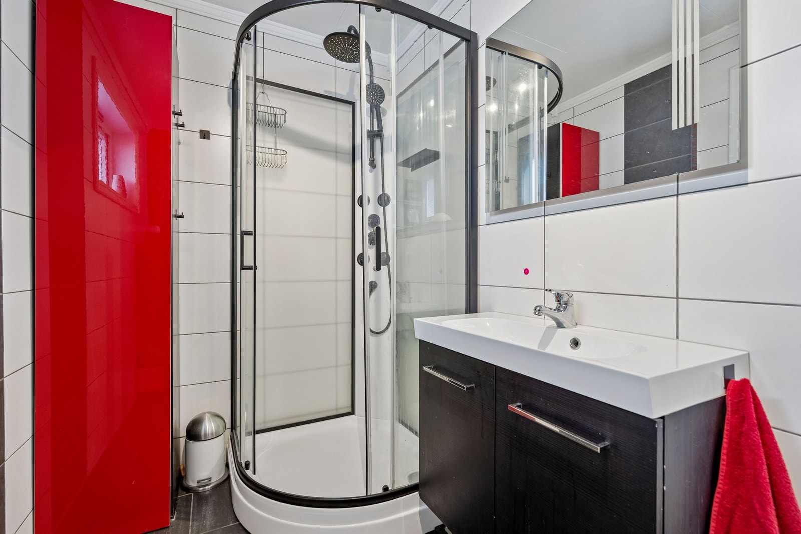 Bad i 1. etasje har flislagt gulv med gulvvarme. Baderomsinnredning med heldekkende servant og glatte fronter. På veggen er det speil med integrert belysning Galleribilde