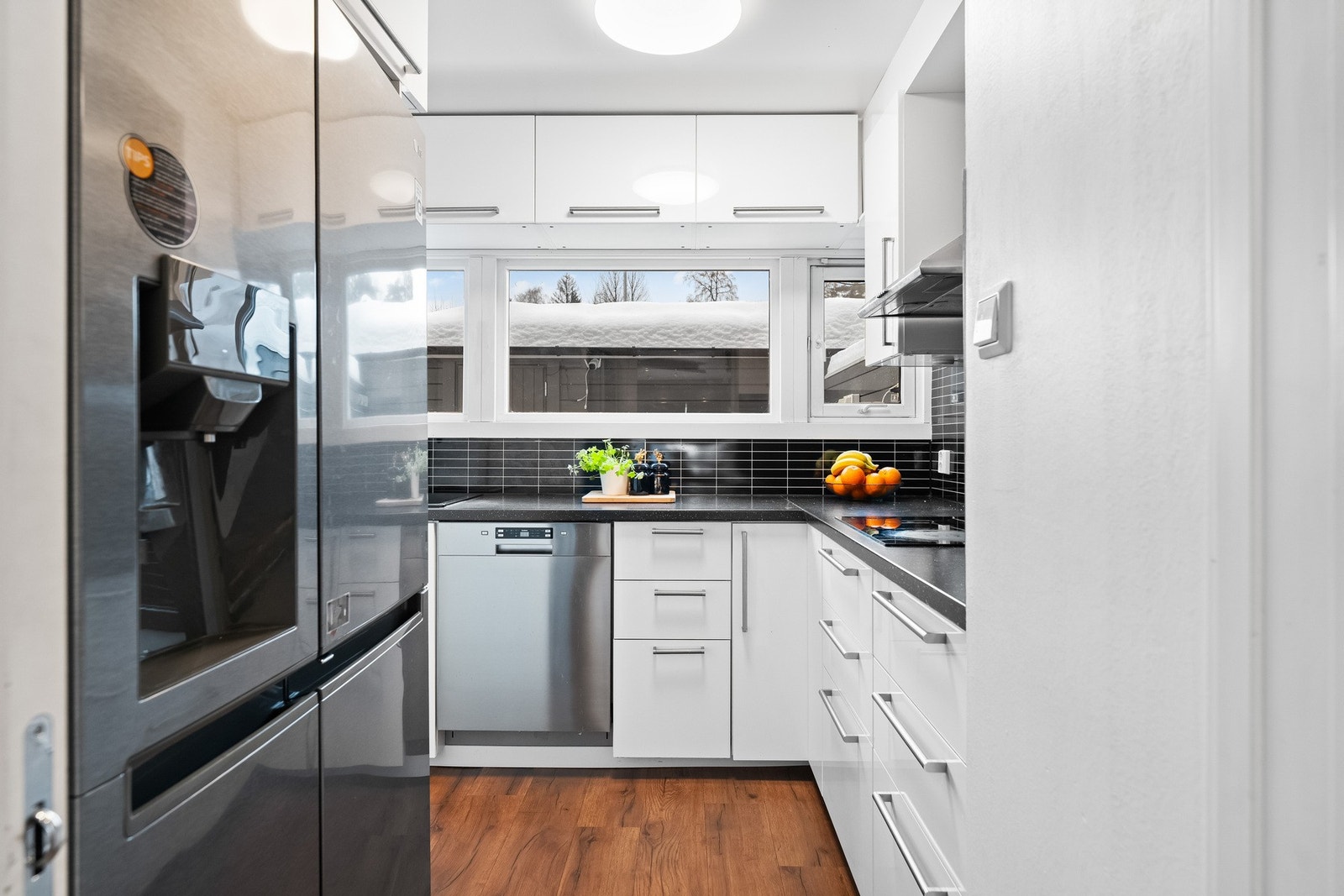 Det er avsatt plass til frittstående side-by-side-kjøleskap (medfølger ikke). Elektrisk ventilator er montert over kokesonen. Galleribilde