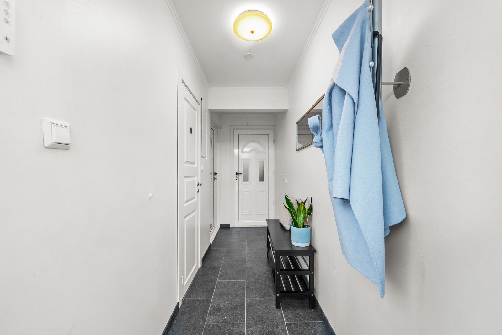 Lys felles entré for hoveddel og hybeldel med malte veggflater og flislagt gulv. Fra entréen er det separate inngangsdører til henholdsvis hoveddel og hybeldel. Galleribilde