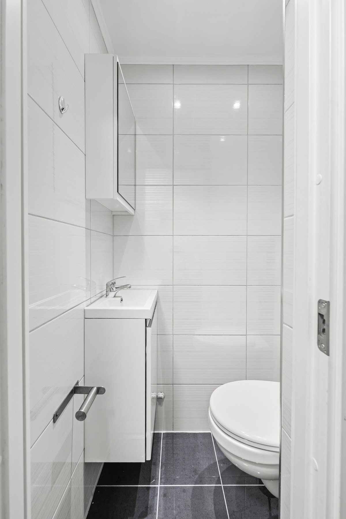 Det er direkte adkomst til et praktisk flislagt toalettrom fra entreen. Galleribilde