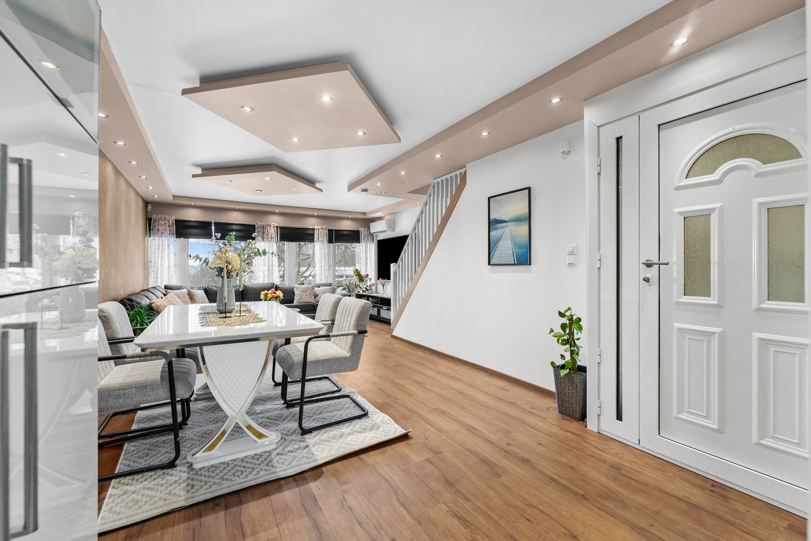 Den åpne stuen/spisestuen fremstår innbydende med lyse, tidsriktige fargevalg og en kontrastvegg med stilren tapet. Galleribilde