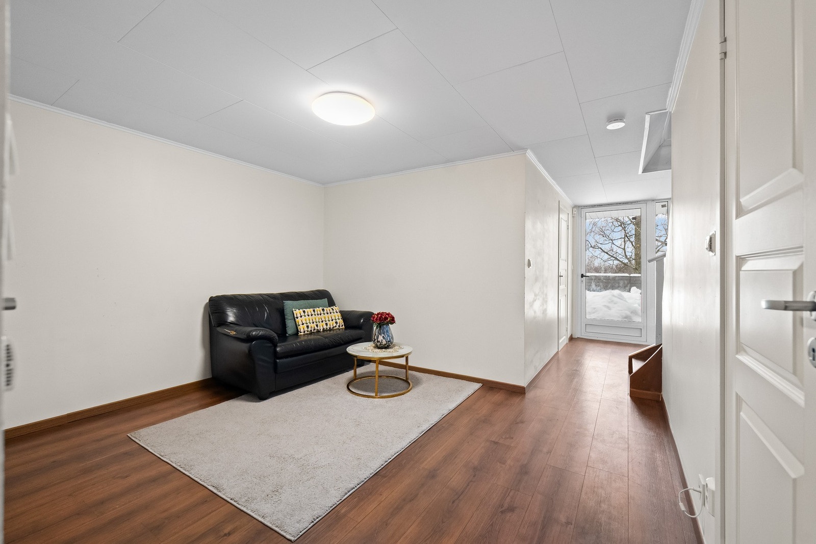 Hybel: Lysinnslipp fra store vindusflater og terrassedør med glassfelt i enden av rommet. Galleribilde