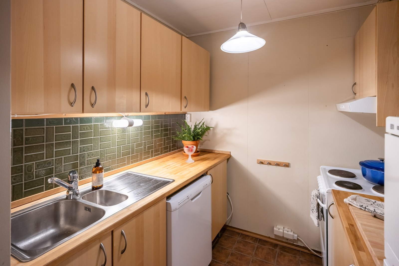 Eget kjøkken i sokkelen med mekanisk avtrekk og god lagring. Galleribilde