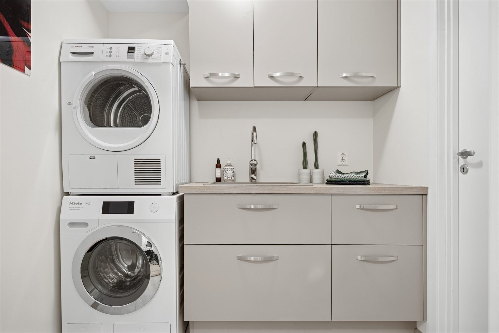 Vaskerommet har flislagt gulv med sluk. Av utstyr er romslig innredning med servant og opplegg for vaskemaskin (Kran og avløp). Innvendig bod til høyre. Galleribilde