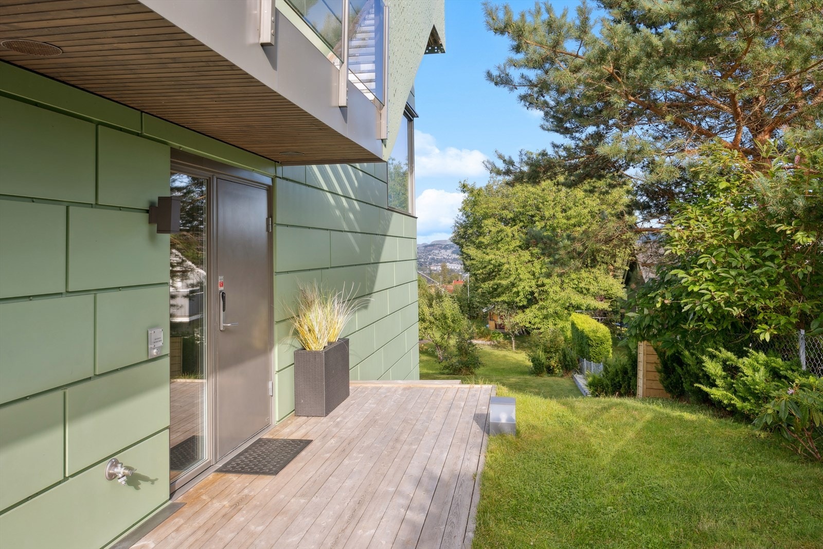 Hovedinngang er i boligens første etasje. Skjermet og innbydende inngangsparti, delvis overbygd. Her kan morgen kaffen nytes. Galleribilde