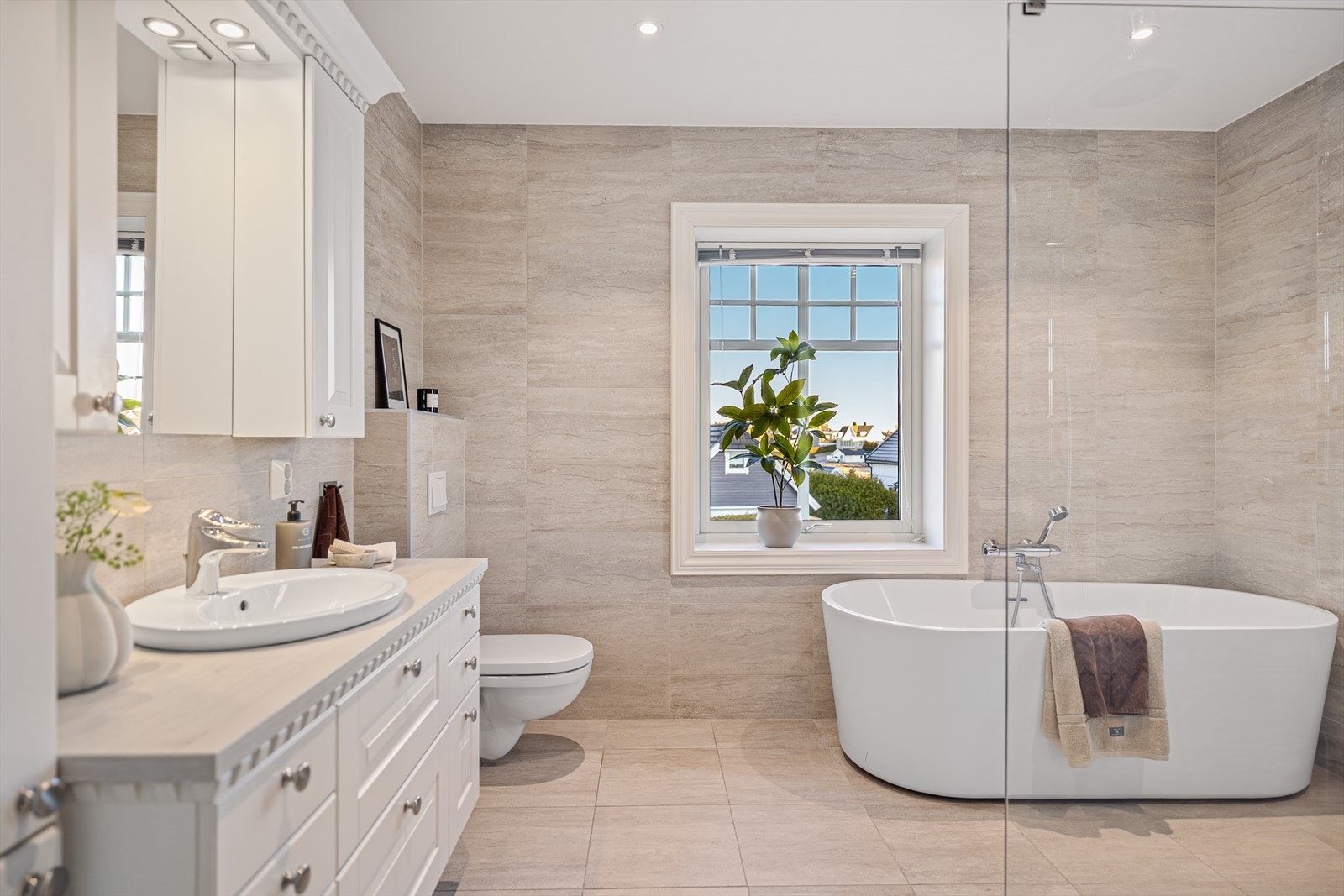 Baderommet fremstår som en ren oase av velvære, med elegante fliser på både gulv og vegger som skaper et tidløst og eksklusivt uttrykk. Her er ingenting overlatt til tilfeldighetene. Galleribilde