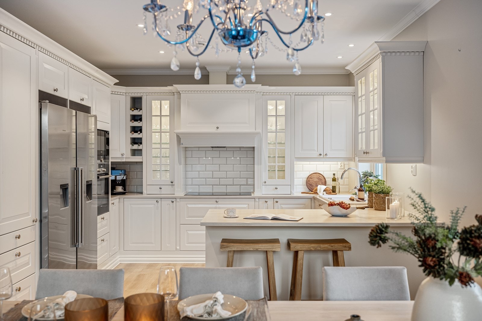 Integrerte hvitevarer som platetopp, oppvaskmaskin, komfyr og mikrobølgeovn gjør arbeidssonene sømløse og ryddige, mens det frittstående kjøle- og fryseskapet med is- og vanndispenser tilfører det lille ekstra av luksus og hverdagskomfort. Galleribilde