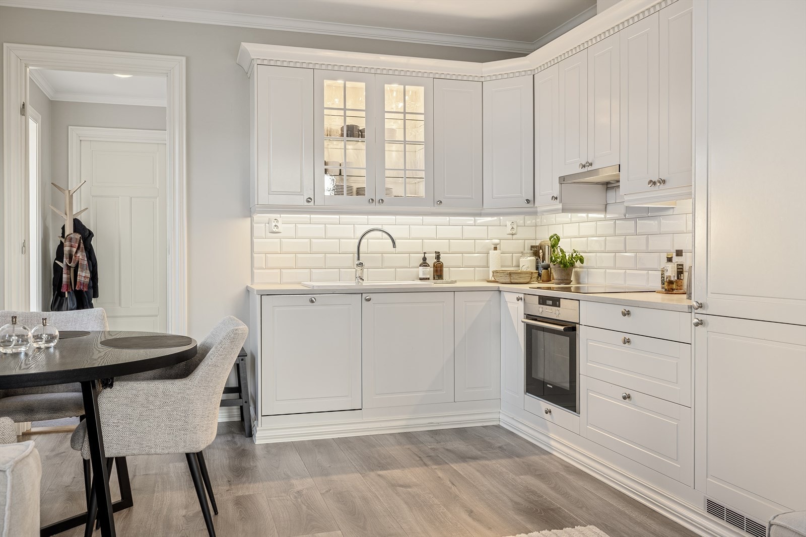 Kjøkkenet ligger i en åpen og moderne løsning mot stuen, noe som skaper en sosial og romslig atmosfære. Denne planløsningen gir en flott flyt mellom sonene og gjør det enkelt å kombinere matlaging, måltider og hyggelig samvær. Galleribilde