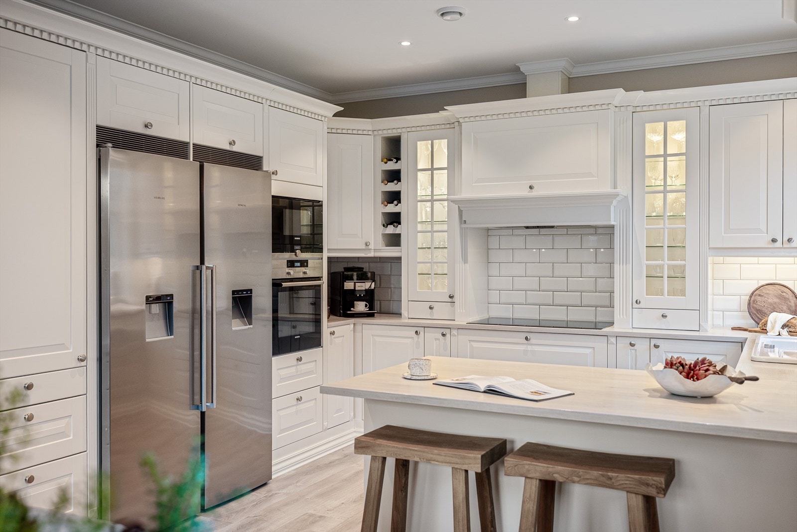 Den lekre innredningen med profilerte fronter gir kjøkkenet et elegant og tidløst uttrykk, samtidig som fargene og materialene harmonerer vakkert med resten av boligens gjennomførte stil. Galleribilde