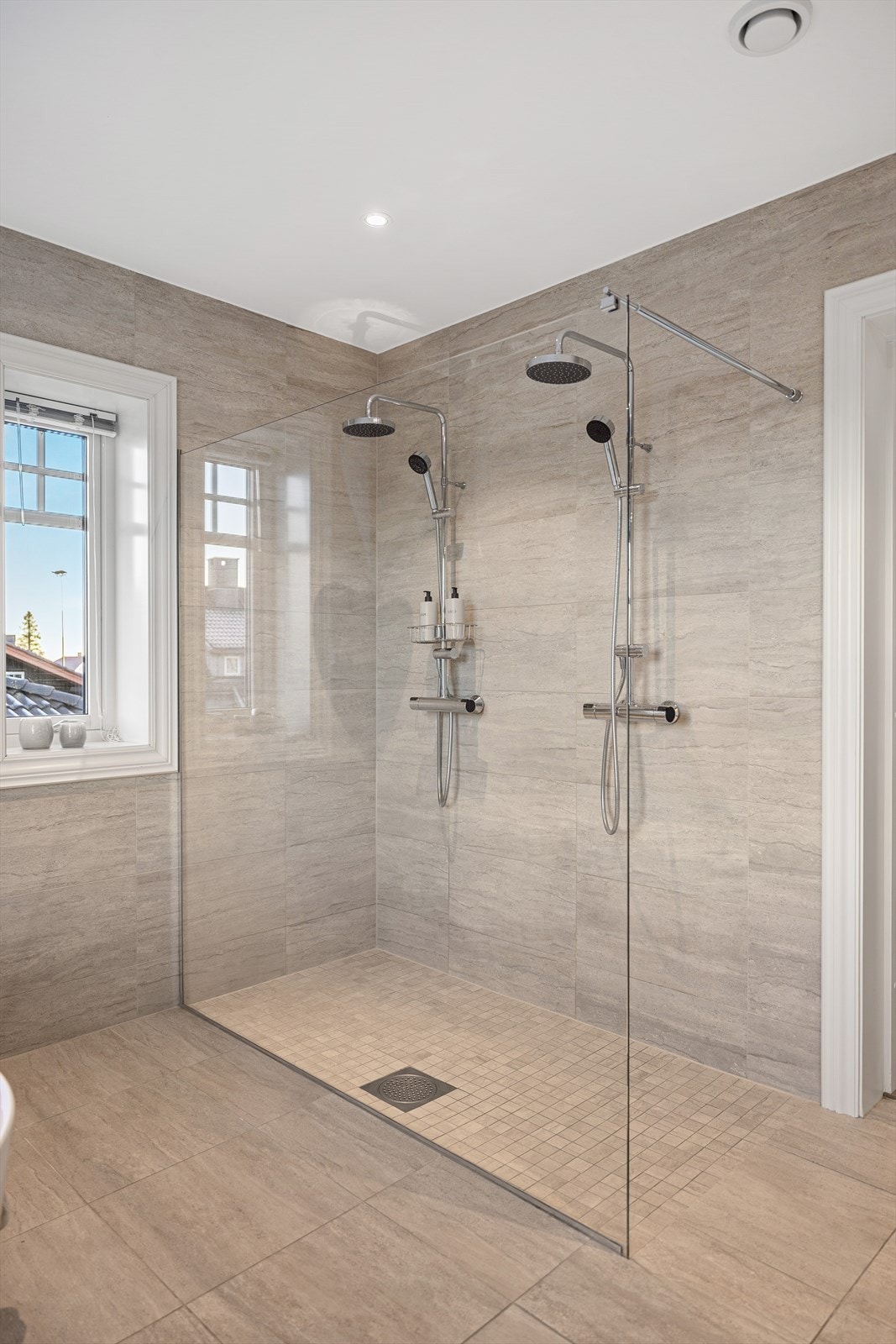 Rommet er innredet med en stor, romslig dusjnise med hele to dusjer og glassvegg - perfekt for en luksuriøs start på dagen. Galleribilde