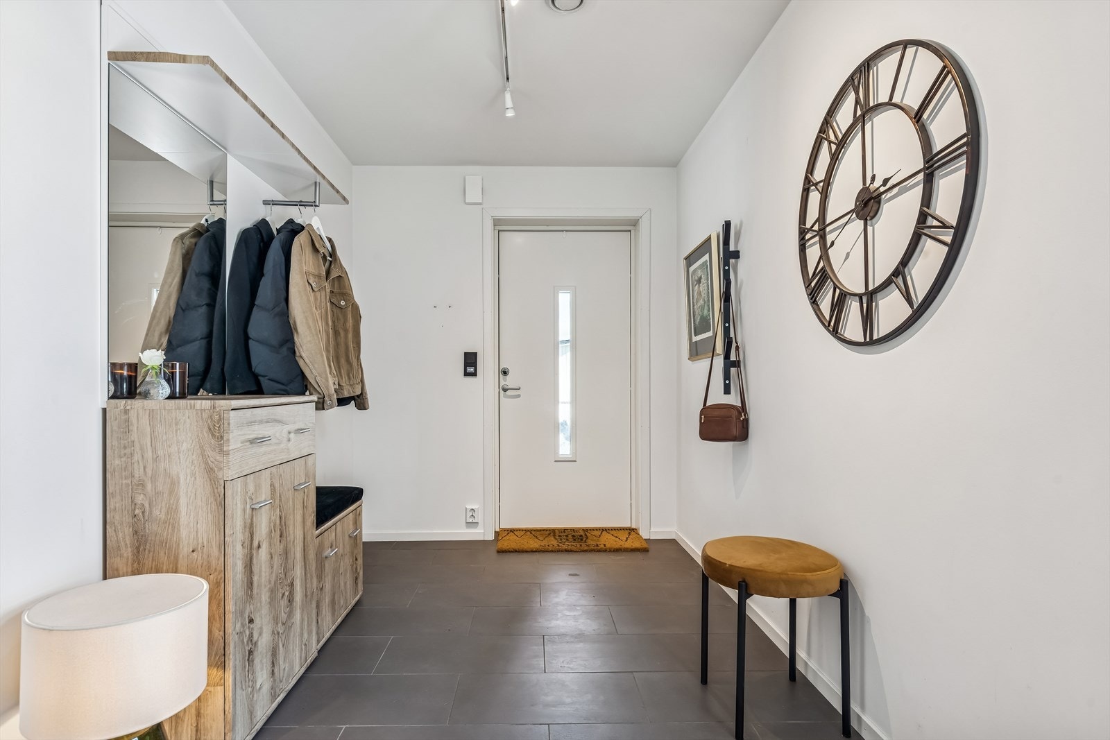 Det er en veldig romslig entre i leiligheten som gir mulighet for et åpent og fint rom som her eller om man skulle ønske en stor og praktisk garderobeløsning. Galleribilde