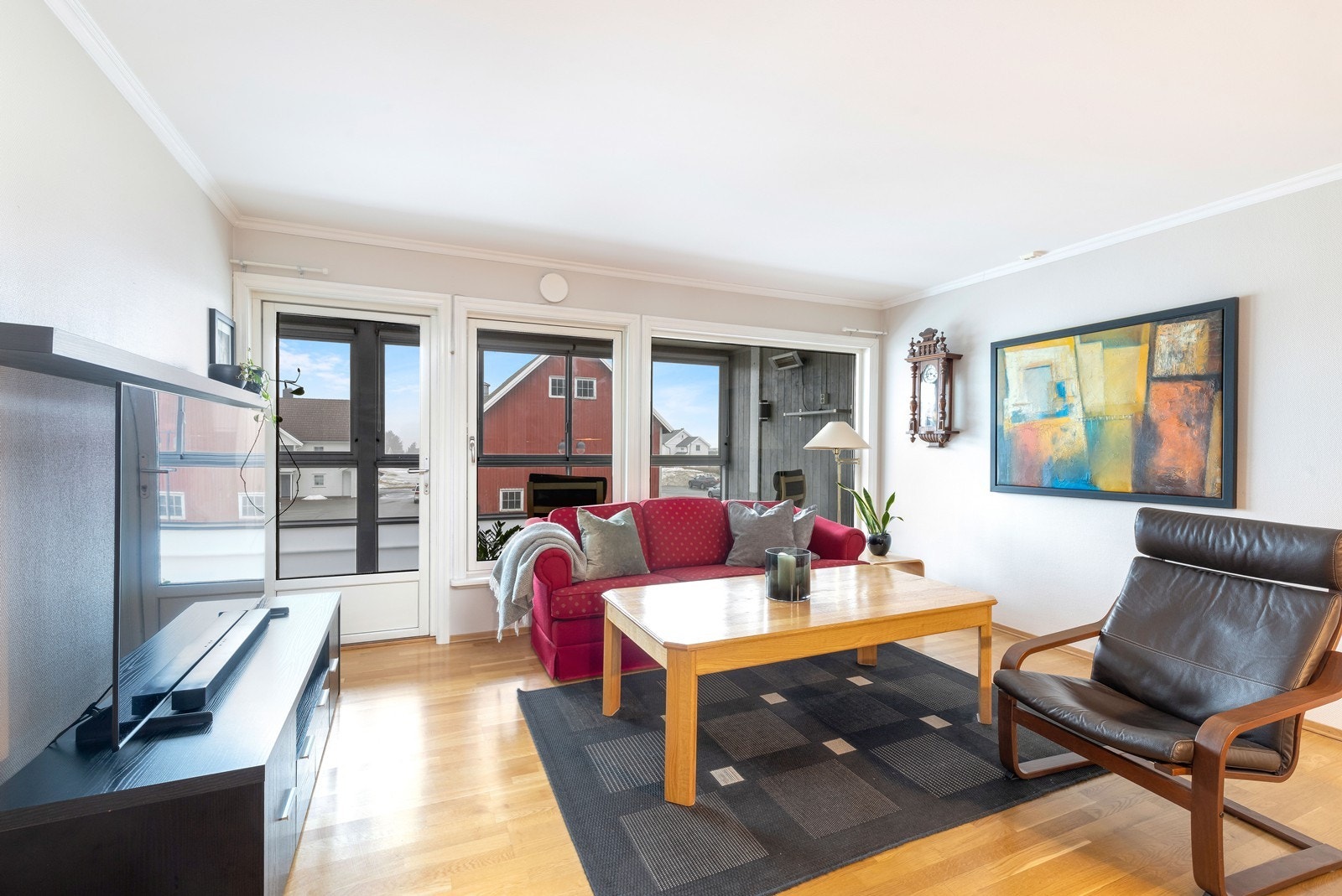 Stue med utgang til en solrik innglasset balkong og bod. Galleribilde