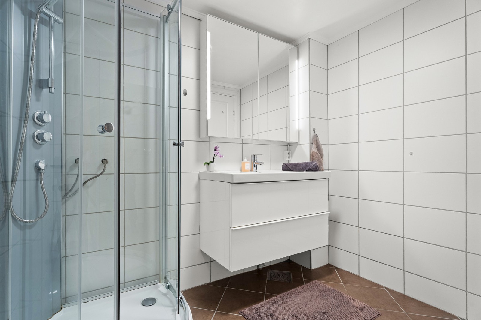 Badet er innredet med skuffeseksjon med servant, speil og belysning på overskap Galleribilde