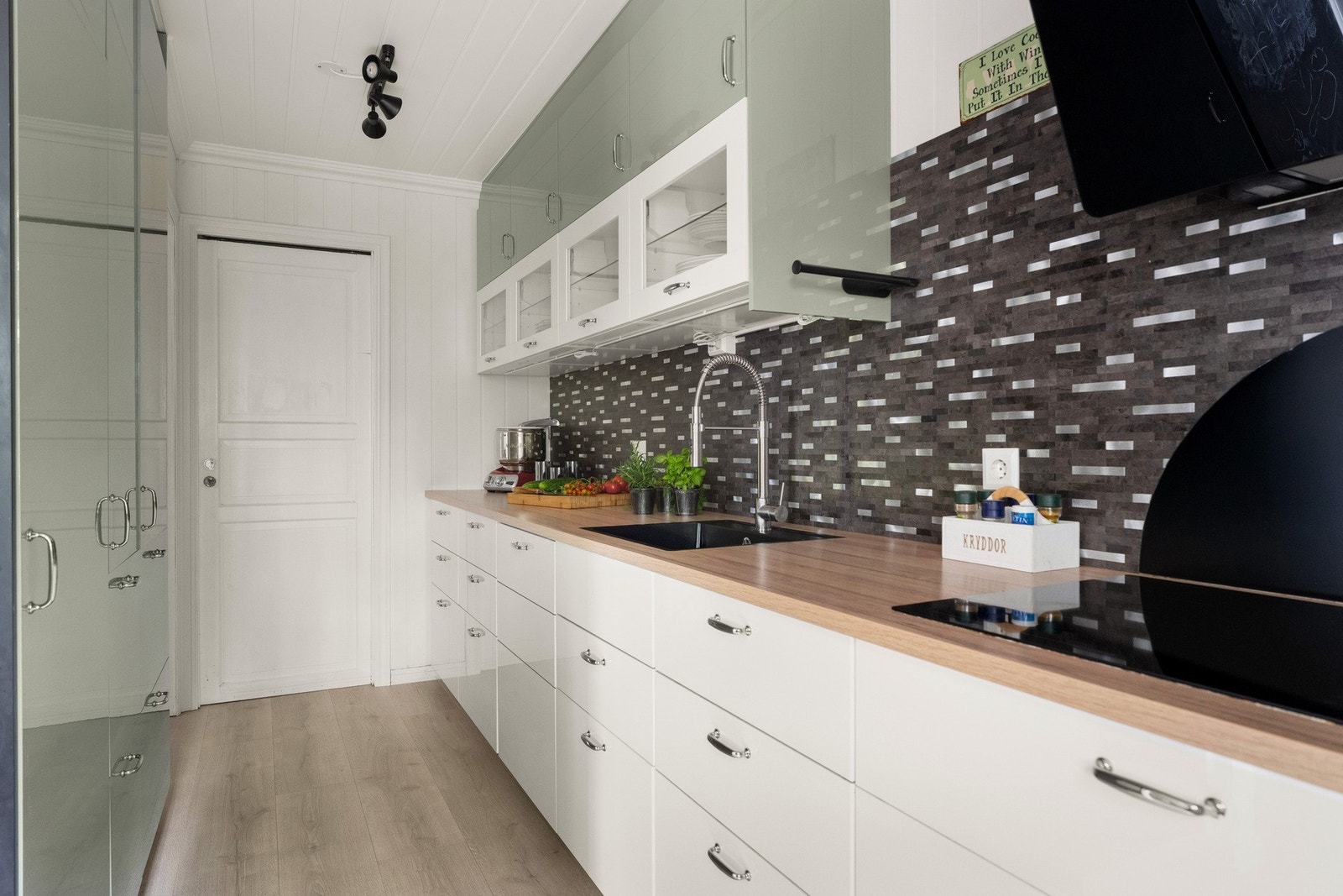 Kjøkkeninnredning med slette fronter og glass i flere overfronter Galleribilde