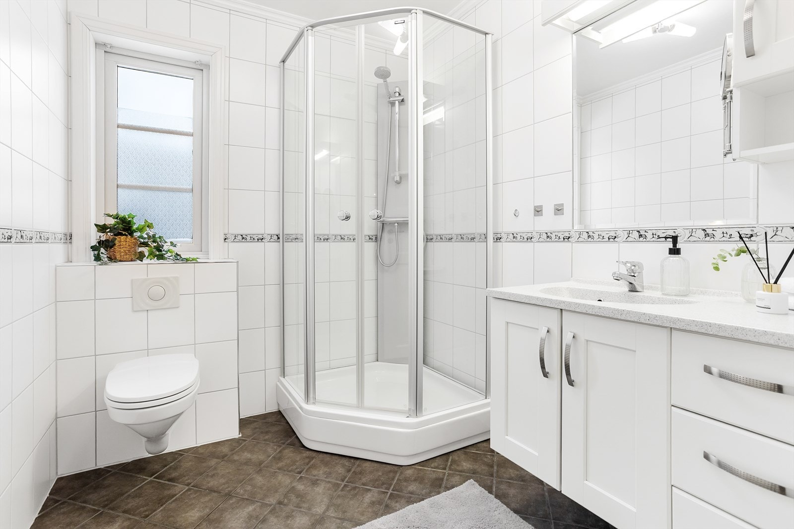 Pent innredet, flislagt bad i 1.etasje med elegant og stor servantinnredning med belysning og god plass til diverse oppbevaring og speil. Galleribilde